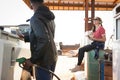 Man filling petrol in car while woman sitting at petrol pump station Royalty Free Stock Photo