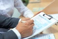 Man filling in U.S. Individual income tax return, tax 1040 at table.