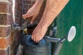 A man holding a watering can underneath an outside tap, during a drought and hosepipe ban in the UK Royalty Free Stock Photo