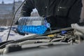 Man filling a windshield washer tank of a car by antifreeze Royalty Free Stock Photo