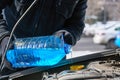 Man filling a windshield washer tank of a car by antifreeze Royalty Free Stock Photo