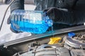 Man filling a windshield washer tank of a car with antifreeze Royalty Free Stock Photo