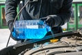 Man filling a windshield washer tank of a car by antifreeze in winter outdoors Royalty Free Stock Photo