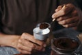 Man fills the funnel of a moka pot with coffee
