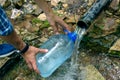 A man fills a plastic bottle with water from an underground source of clean water