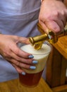 A man fills a plastic glass with beer