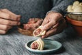 Man fills some Catalan galets with ground meat