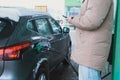 a man fills up his car and pays for gas through an application on his phone Royalty Free Stock Photo