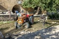 A man fills a water tanker towed behind a tractor.