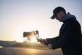 Man filming with camera and gimbal against city at sunrise Royalty Free Stock Photo