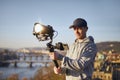 Man filming with camera and gimbal against urban skyline Royalty Free Stock Photo