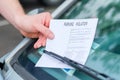 Man finding a ticket fine under the car windscreen because of parking violation Royalty Free Stock Photo