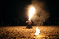 Man fire juggler performing at night on a sandy beach Royalty Free Stock Photo