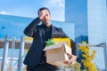 Man fired from his job unemployment concept. Dismissed employee carrying cardboard box with office stuff Royalty Free Stock Photo