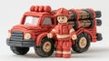 A man in a fireman's outfit stands next to a red toy fire truck