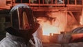 A man in a fireproof suit stands in the smelting shop of a metallurgical plant.