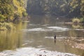 Man, fisherman, fishing inside the waters of the Juzna Morava river with his rod.