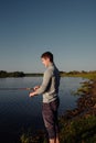 A man fisherman on the river bank catches a fish Royalty Free Stock Photo