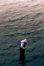 Man fishing alone while standing in water