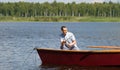 Man fishing in a boat, against the open water and sky Royalty Free Stock Photo