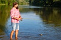 Man fishing. Fly fisherman using fly fishing rod in beautiful river. Man with fishing rods on river berth. Concepts of