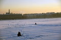 A man fishing on a frozen Neva river in historical city center of Saint-Petersburg