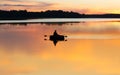 Man fishing on lake from boat at sunset or sunrise time. Fisherman silhouette at sunset Royalty Free Stock Photo