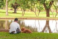 Man fishing in lake next to his friend dog