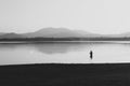 A man is fishing in the lake at sunset. Wetland and mountain landscape Royalty Free Stock Photo