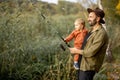 Man fishing with little son on lake coast Royalty Free Stock Photo