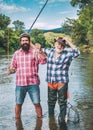 Man fishing. Men fishing in river during summer day. Father and son fishing. Fly rod and reel with a brown trout from a Royalty Free Stock Photo