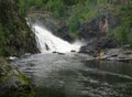 Man fishing near waterfall