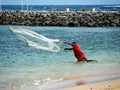 MAN FISHING WITH NETWORK AT SEA