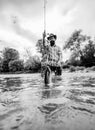 Man fishing and relaxing while enjoying hobby. Happy fisherman fishing in river holding fishing rods. Steelhead rainbow Royalty Free Stock Photo