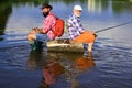 Man fishing and relaxing while enjoying hobby. Two fishermen with fishing rod on the river. Happy grandfather and
