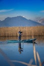 Man fishing in river, capturing fish with a net from the boat in Metkovic, Croatia Royalty Free Stock Photo