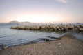 Man fishing on the rocks of the tidal barrier at sunset. Amusement.