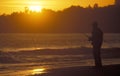 Man fishing in the sea at sunset