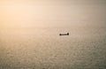 A small boat floating in a lake with town in the morning fog Royalty Free Stock Photo