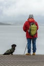 Man on a fishing trip on a pier with a dog Royalty Free Stock Photo