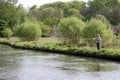 A man fishing for Trout in the River Coln in Bibury, Gloucestershire in the UK Royalty Free Stock Photo