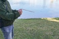 a man is standing by the water with a fishing pole Royalty Free Stock Photo