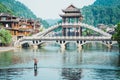 Man fishing on water at the river Tuojiang in the Ancient city of China, Fenghuang. Traditional Chinese bridge. Village of the Royalty Free Stock Photo