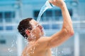 Man fitness runner drinking and splashing water in her face. Royalty Free Stock Photo