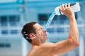 Man fitness runner drinking and splashing water in her face. Royalty Free Stock Photo