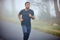 Man, fitness and running on road in nature for cardio workout, exercise or training outdoors. Fit, active or athlete Royalty Free Stock Photo