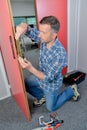 Man fitting lock to interior door