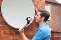 Man Fitting TV Satellite Dish To House Wall Royalty Free Stock Photo