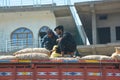 Man fix potatoes bags on the top of a truck