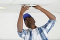 man fixes ceiling skirting